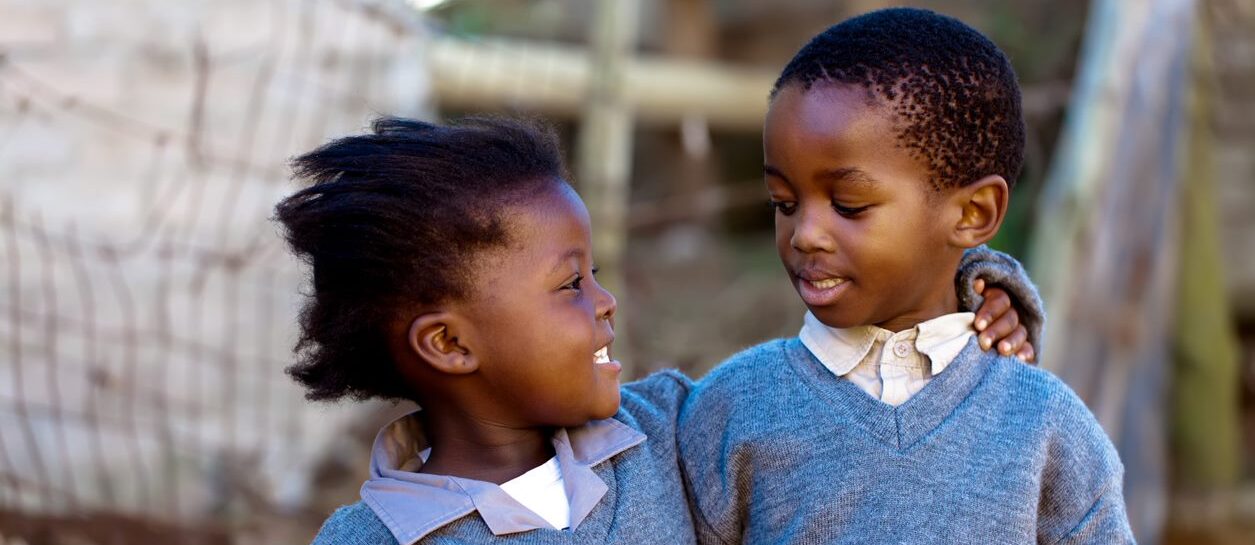 Two children arm in arm